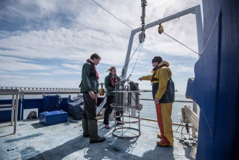 Scientist standing on a boat in the middle of the water.