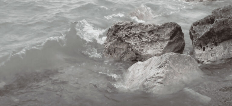 Rocks with water splashing up onto them.